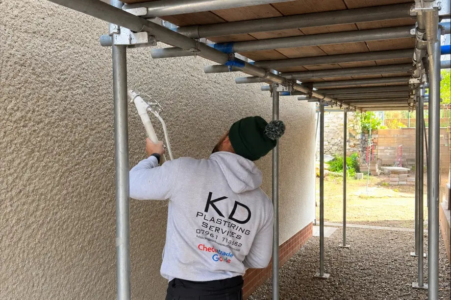 KD Plastering applying sprayed cream monocouche render to a house exterior