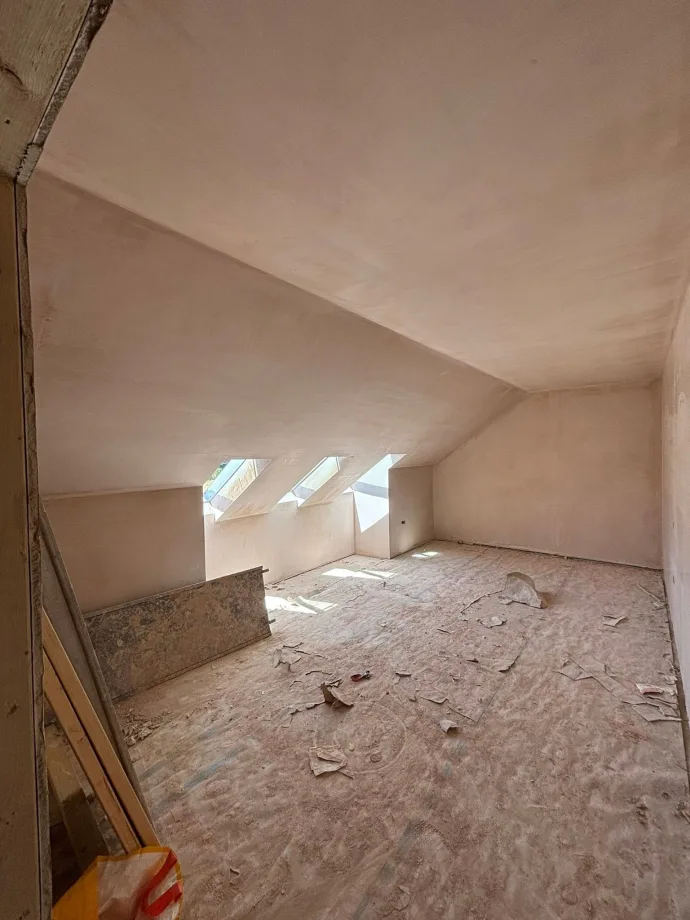 Loft room with three Velux windows and sloping ceilings, fully skimmed