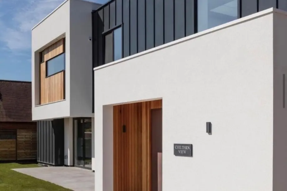 New-build home finished in smooth off-white silicone render with anthracite cladding
